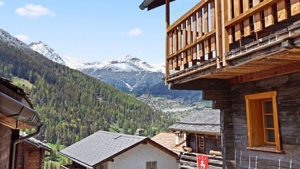 A wooden chalet with a balcony overlooking a mountainous landscape. - Charming apartment in an authentic village (Anniviers)