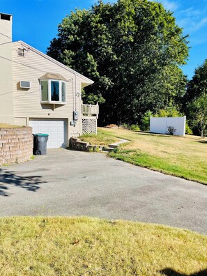 A single-story house with a garage, a small front yard, and a large tree. - Kennebunk Family Retreat Near Downtown with Beach Passes (Kennebunk)
