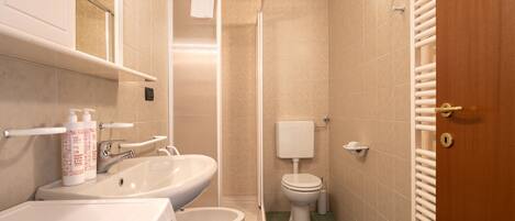 A bathroom with a sink, toilet, and shower.