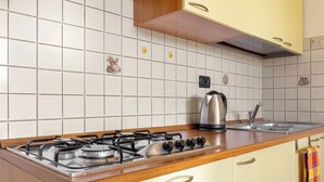 Eine Küche mit Gasherd, Wasserkocher und Spüle.