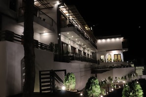 A multi-story building with balconies, outdoor lighting, and a gated entrance. - Ventus Pines  (Kasauli)