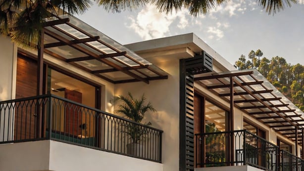 Un hotel de varios pisos con balcones, ventanas amplias y un diseño arquitectónico moderno.