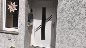 Fachada de edificio con puerta, ventana y buzón.
