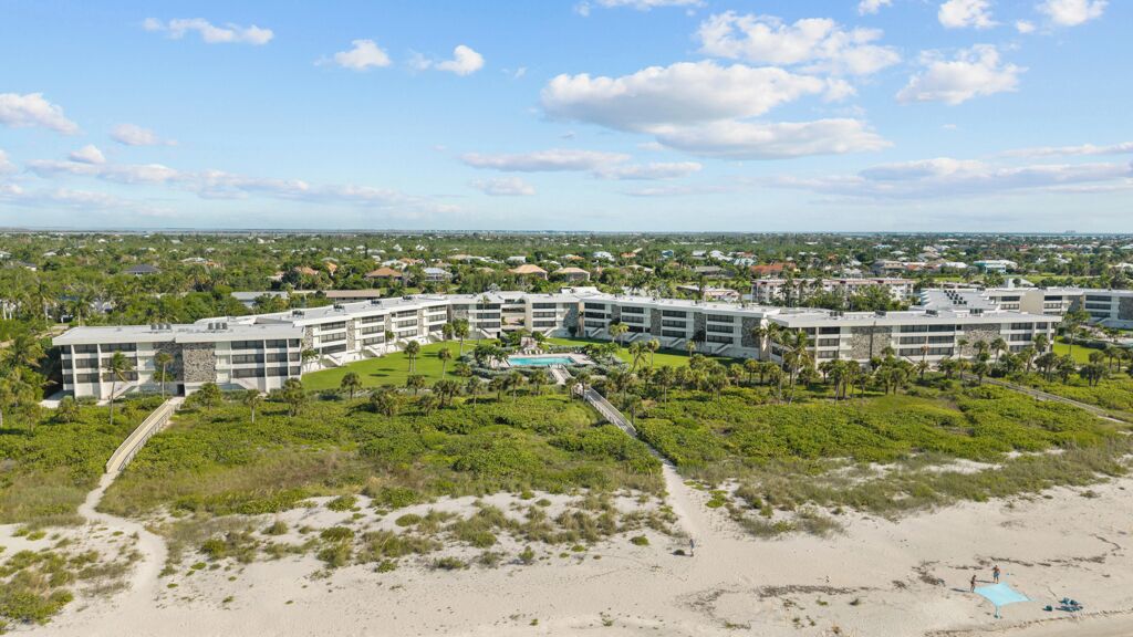 A resort with multiple buildings, a pool, and a beach area.