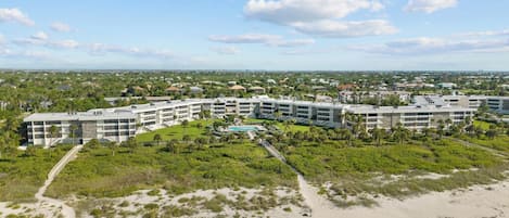 A resort with multiple buildings, a pool, and a beach area.
