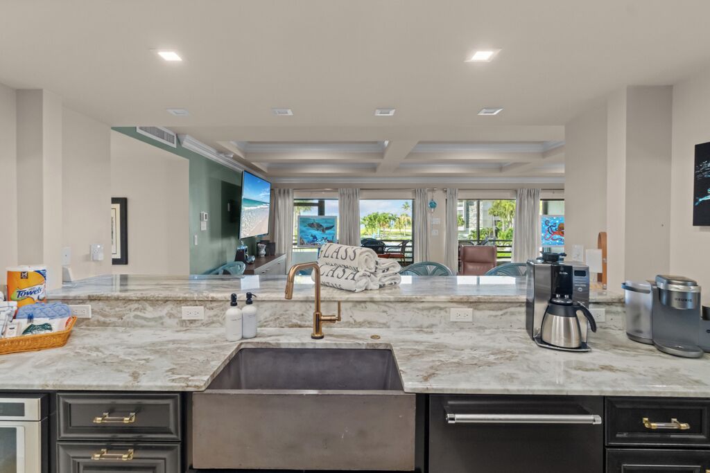 Una cocina moderna con encimera de mármol, electrodomésticos de acero inoxidable y vistas al exterior.