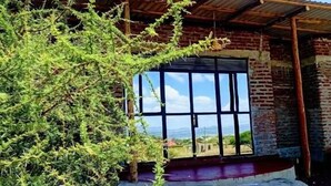 Un bâtiment doté d’une grande fenêtre, d’une entrée abritée et offrant une vue sur le ciel.