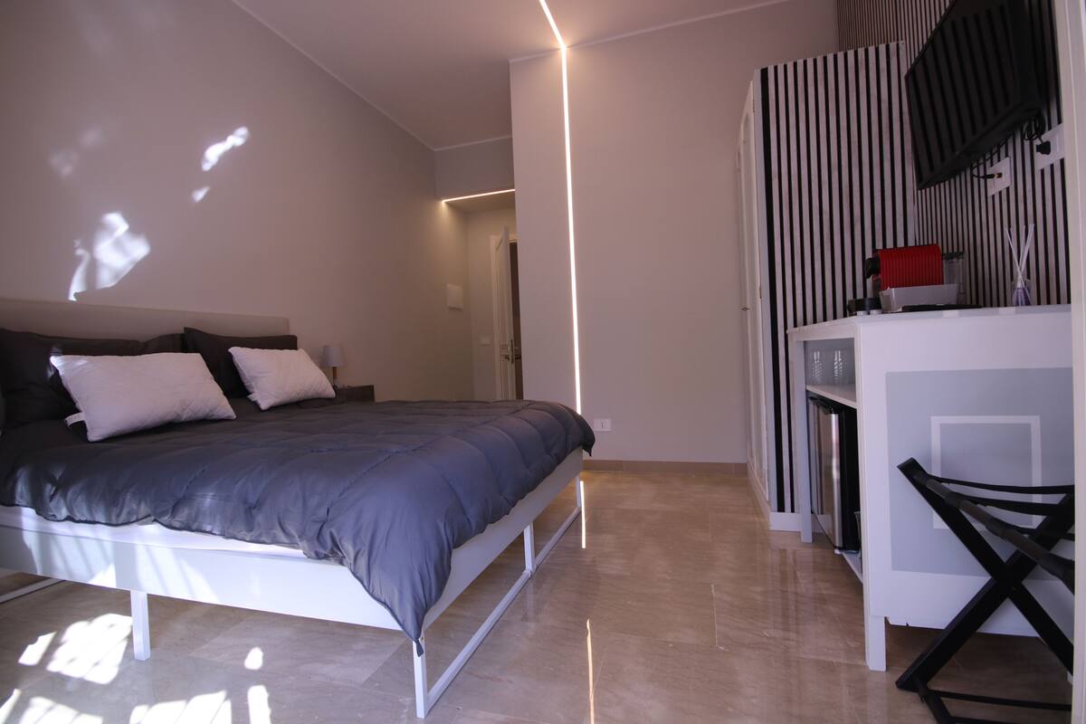 Un dormitorio con una cama, un escritorio y una silla.