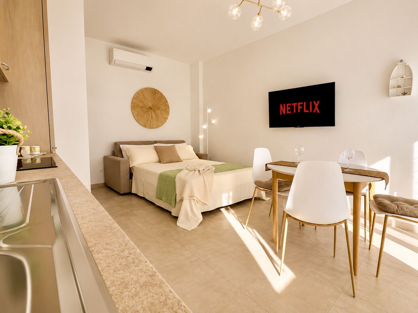 Un dormitorio moderno con cama, mesita de noche y televisor de pared mostrando 'NETFLIX'.