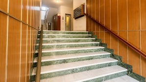 A staircase with marble steps and wooden paneling on the walls. - 1-Bedroom Apt 30m from Sea | AC | Terrace | Bike Friendly + Box (Finale Ligure)