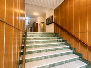 Portaat, joissa on marmorista tehdyt askelmat ja seinissä puupanelointi.