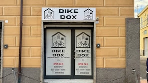 A bike storage facility with a sign indicating it's open 24 hours for bike parking and luggage storage. - 1-Bedroom Apt 30m from Sea | AC | Terrace | Bike Friendly + Box (Finale Ligure)