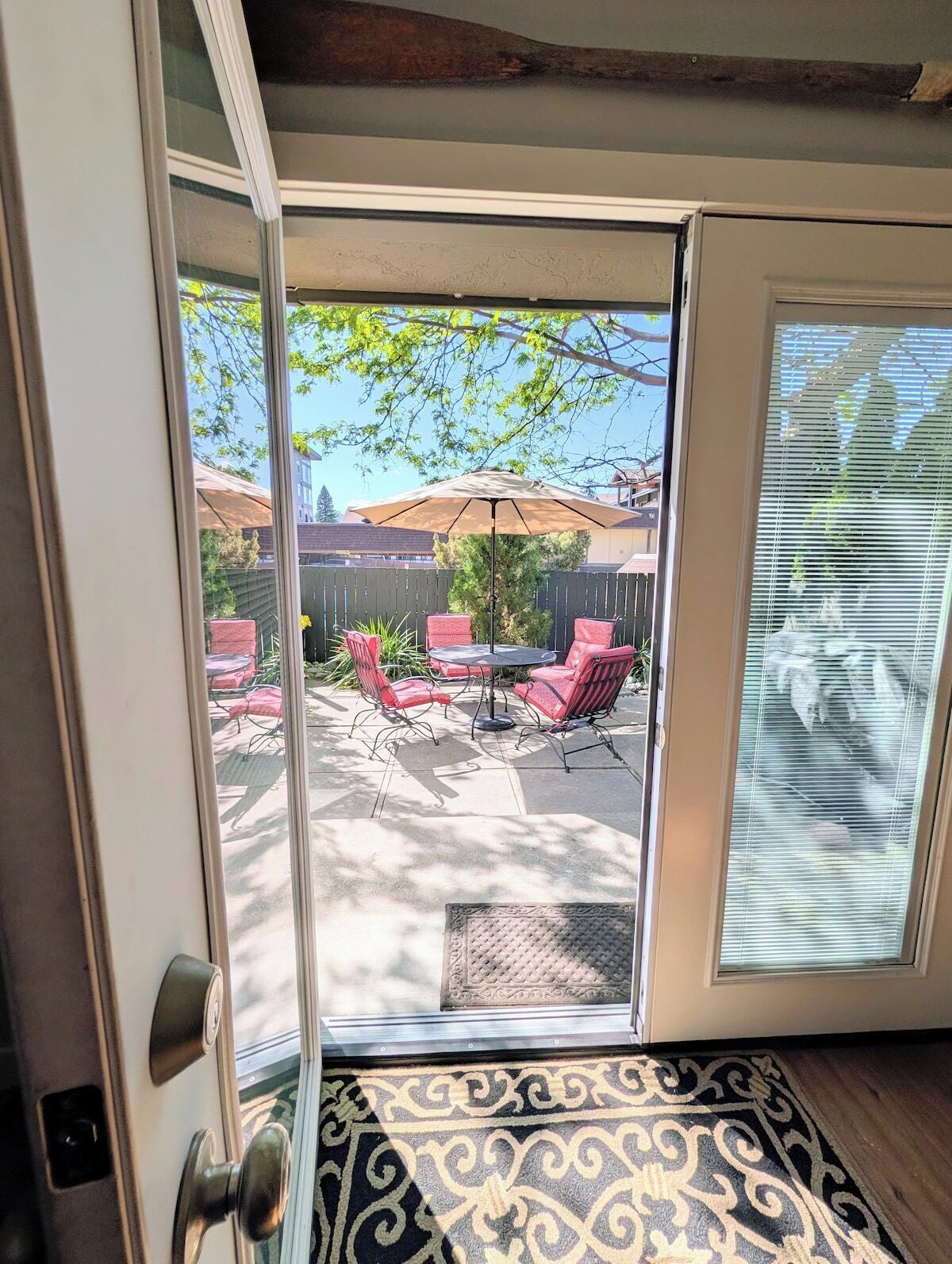A sliding glass door leading to an outdoor patio with a table and chairs.