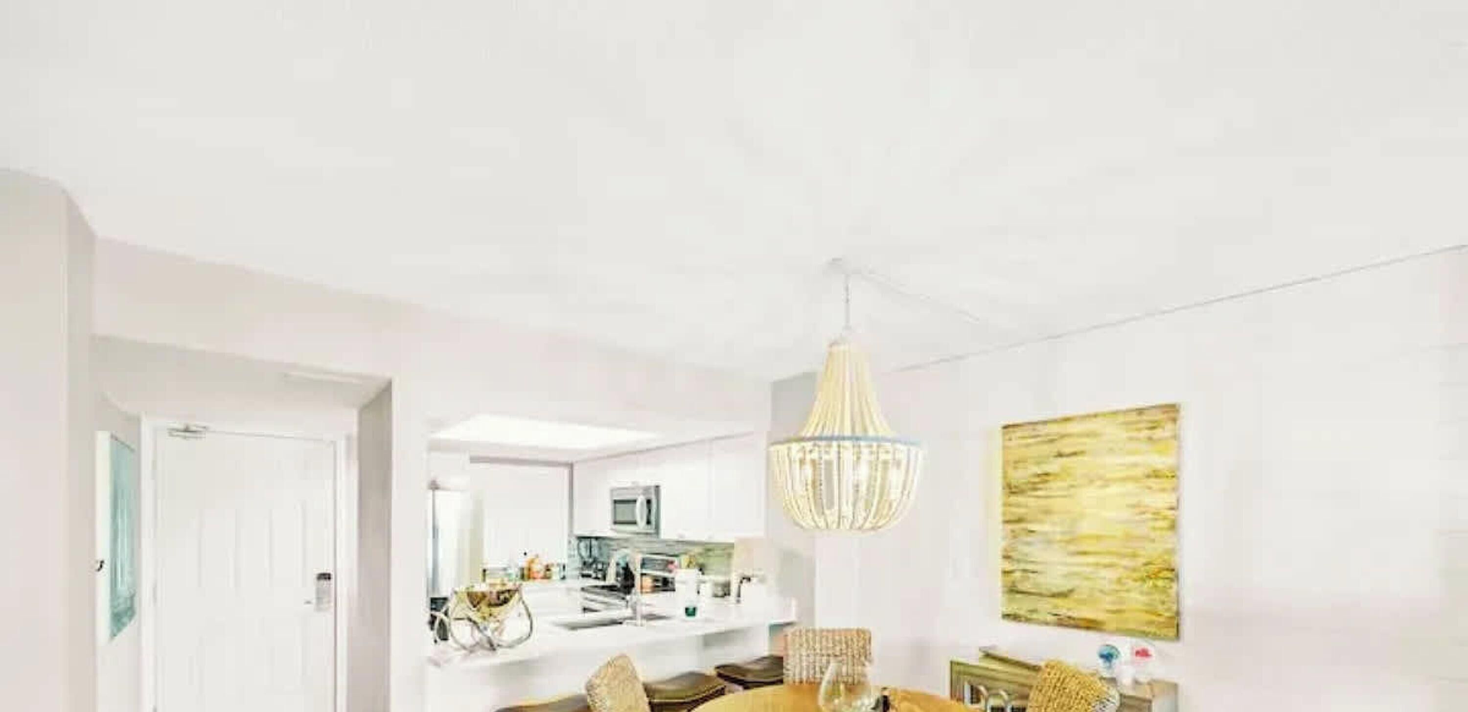 Un intérieur moderne comprenant un coin repas, une cuisine et un lustre.
