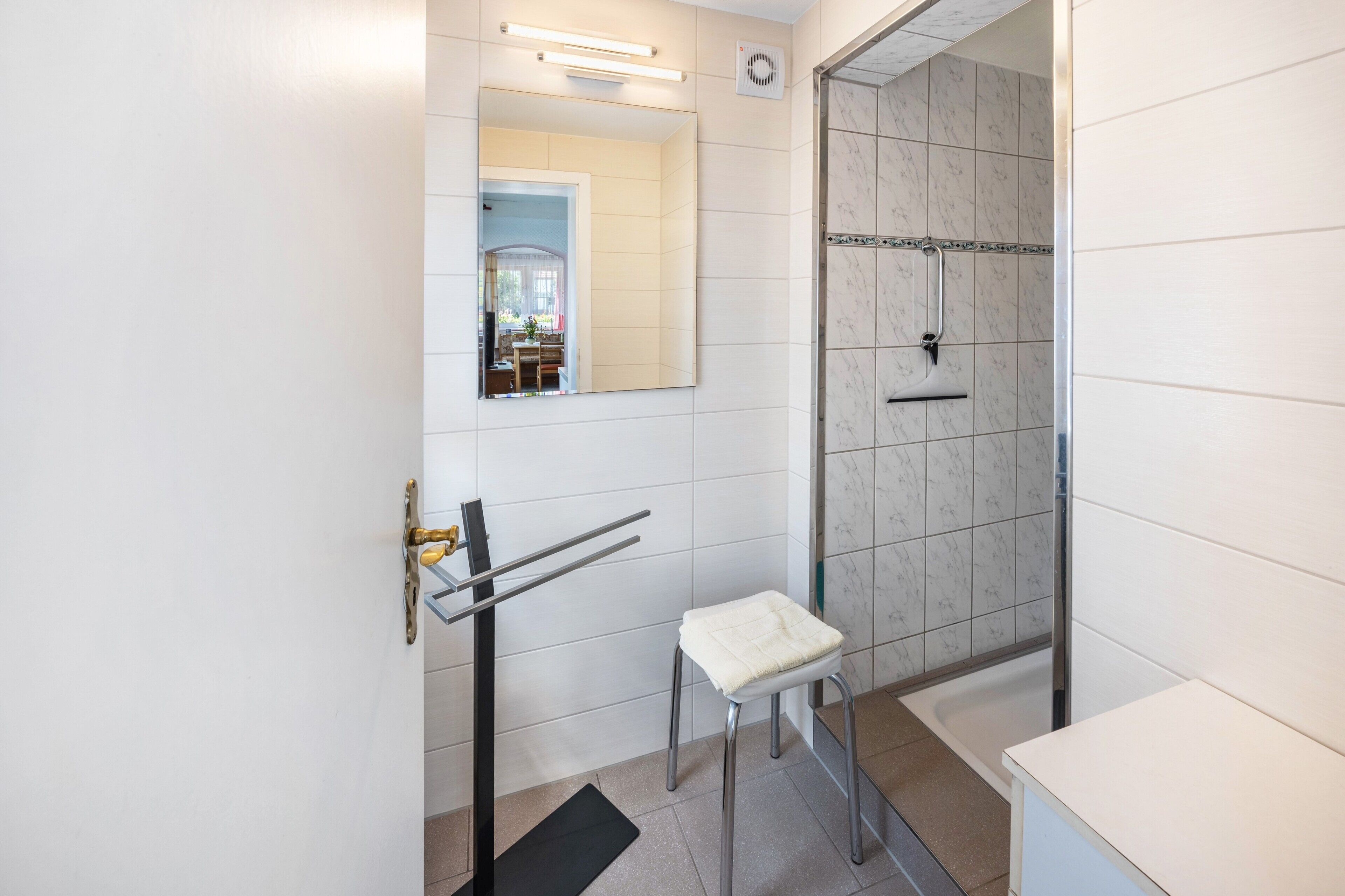 Ein Badezimmer mit Dusche, Toilette, Waschbecken und Spiegel.