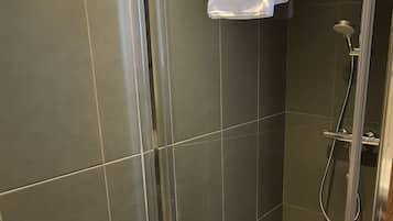 Een douche, handdoeken, zeep, shampoo