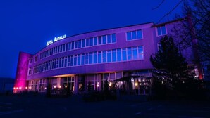 Un hotel de diseño moderno, con un letrero llamativo, múltiples ventanas y una entrada bien iluminada.