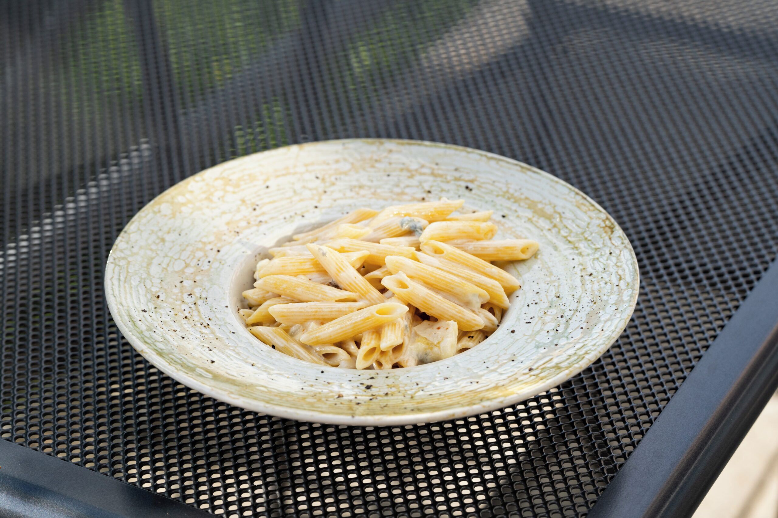 Un plato de pasta sobre una mesa de metal.