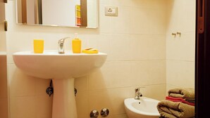A bathroom with a sink, mirror, and towel rack.