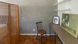 A room with a wooden parquet floor, a wooden chair, a table, and a framed picture on the wall. - Charming 1-bedroom loft in downtown Rio de Janeiro. (Rio de Janeiro)