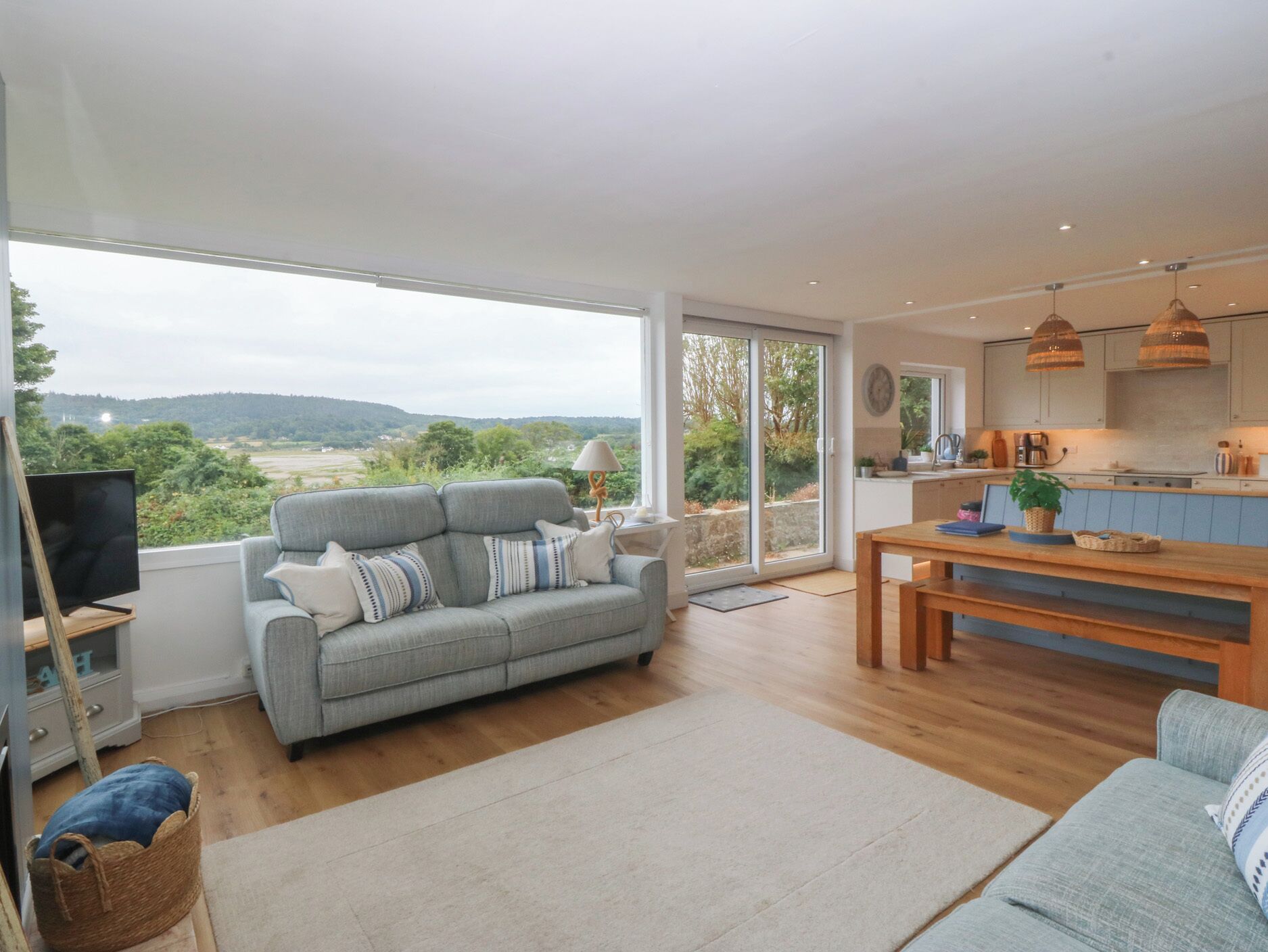 A spacious living area with a sofa, a dining table, and a view of the outdoors.