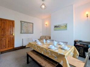 Ein Essbereich mit einem Tisch für vier Personen, einer Karte an der Wand und einer Tür.