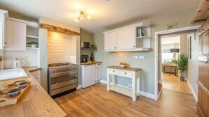 A compact kitchen with a stove, oven, microwave, and white cabinetry.