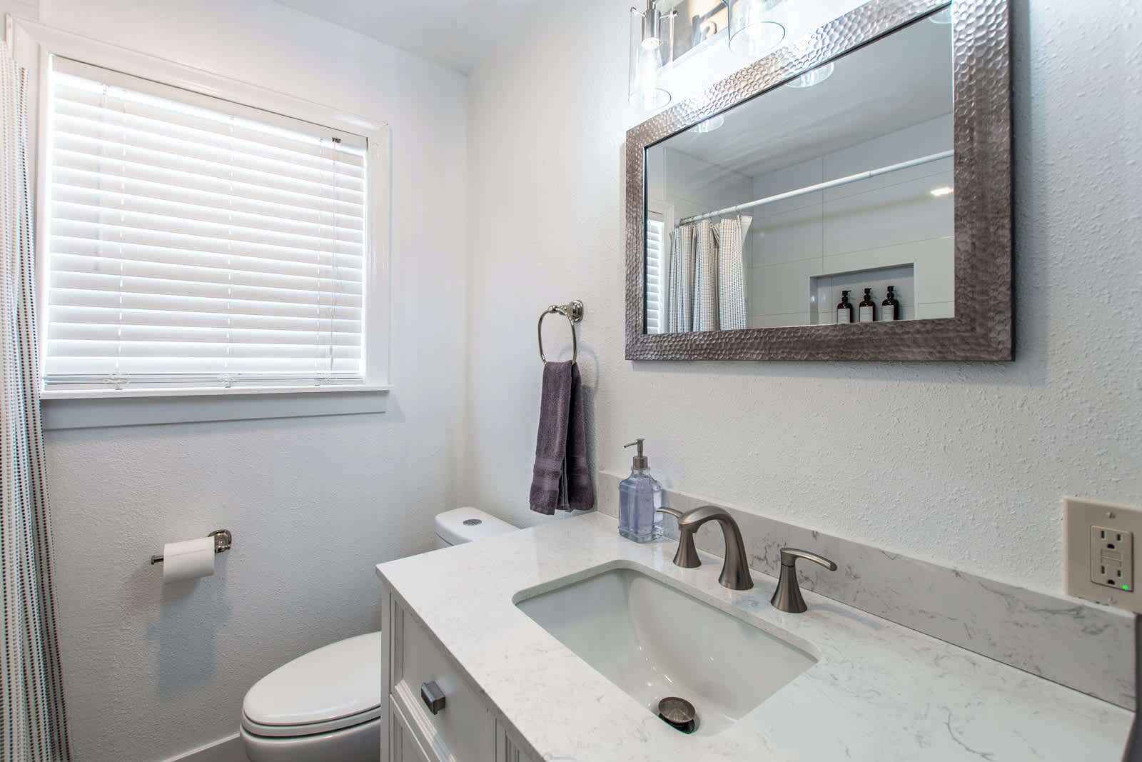 Une salle de bain avec des toilettes, un lavabo et un miroir.