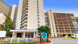 Un hotel con piscina, un cartello con la scritta 'Sea Watch' e un parcheggio.
