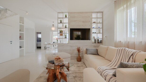 Ein modernes Wohnzimmer mit Sofa, Couchtisch und TV-Wand.