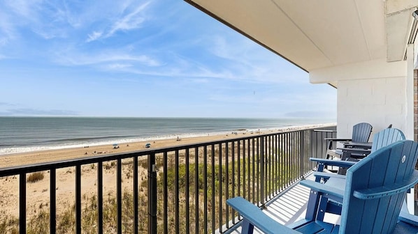 Ein Balkon mit Blick auf Strand und Meer.