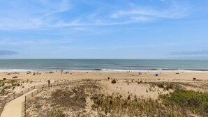 A beach with a fence, sand dunes, and the ocean. - Bimini 306 (Ocean City)
