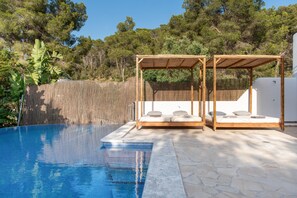 A pool with a wooden pergola and a white wall in the background. - Villa 'Amarantos' with Mountain View, Wi-Fi and Air Conditioning (Santa Eulària des Riu)