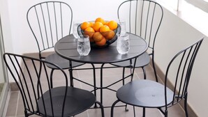 A round table with a fruit bowl and glasses, surrounded by four chairs. - TelMar Central Modern Retreat (Larnaka)