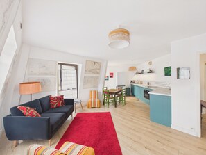 Eine moderne Wohnung mit Essbereich, Küche und Wohnzimmer.