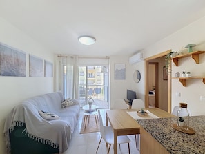 Ein modernes Apartment mit Wohnzimmer, Essbereich und einem Balkon.