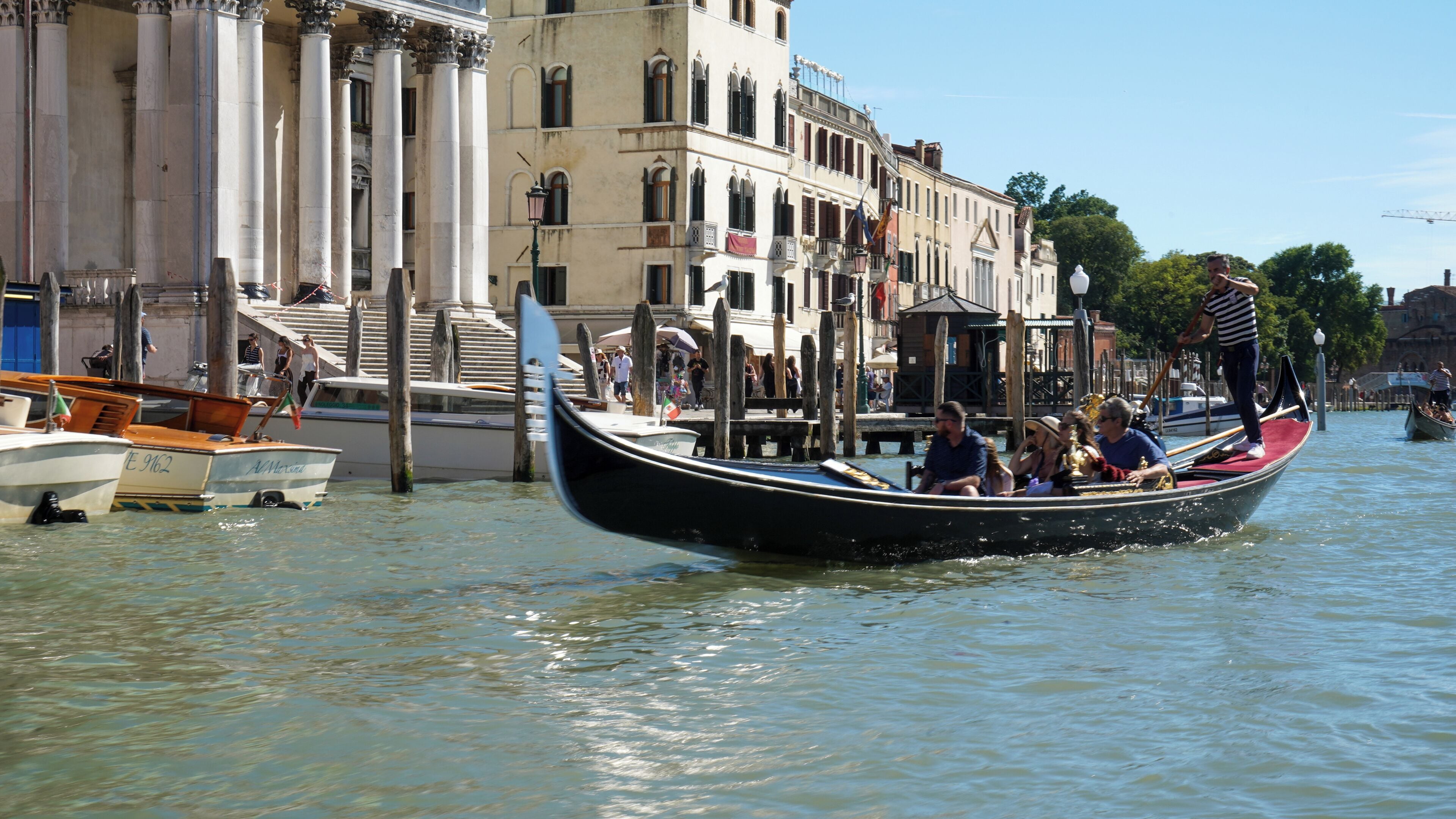 A gondola on a canal with buildings in the background.