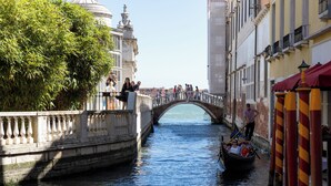 A canal with a bridge, gondolas, and people on the bridge. - Dalèt (Venice)