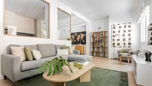Un salon moderne avec un canapé gris, une table basse en bois et un tapis vert.