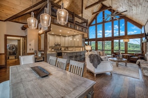 Ein großzügiger Loft-Wohnbereich mit Esstisch, Küche und Blick ins Freie.