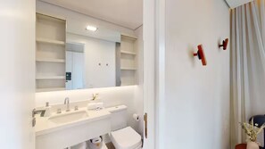 A modern bathroom with a large mirror, two sinks, a toilet, and a shower area. - Arte Itaim (São Paulo)