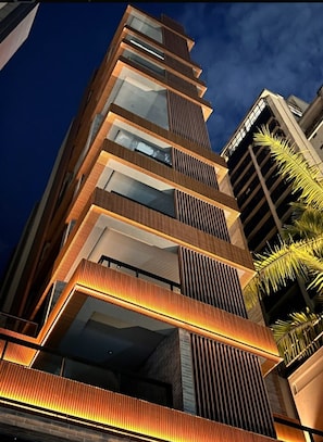 Ein mehrstöckiges Gebäude mit modernem Design, das Balkone und große Fenster aufweist.