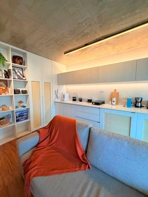 Ein modernes Wohnzimmer mit einer Couch, einem Couchtisch und einem Bücherregal.
