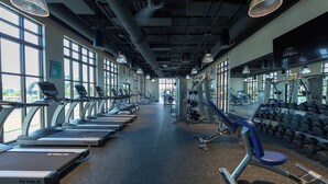 Un gimnasio con cintas de correr, mancuernas y equipamiento de ejercicio.