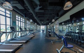 Ein Fitnessstudio mit Laufbändern, Hanteln und Trainingsgeräten.
