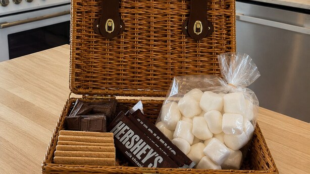 En fletkurv med hanke, der indeholder en Hershey's mælkechokoladebar, skumfiduser og en chokoladebar.