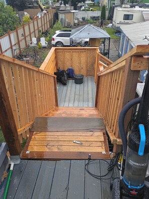 A wooden deck with a metal staircase leading to a covered area. - Tranquil 1-bedroom house with AC in welcoming Salem (Salem)
