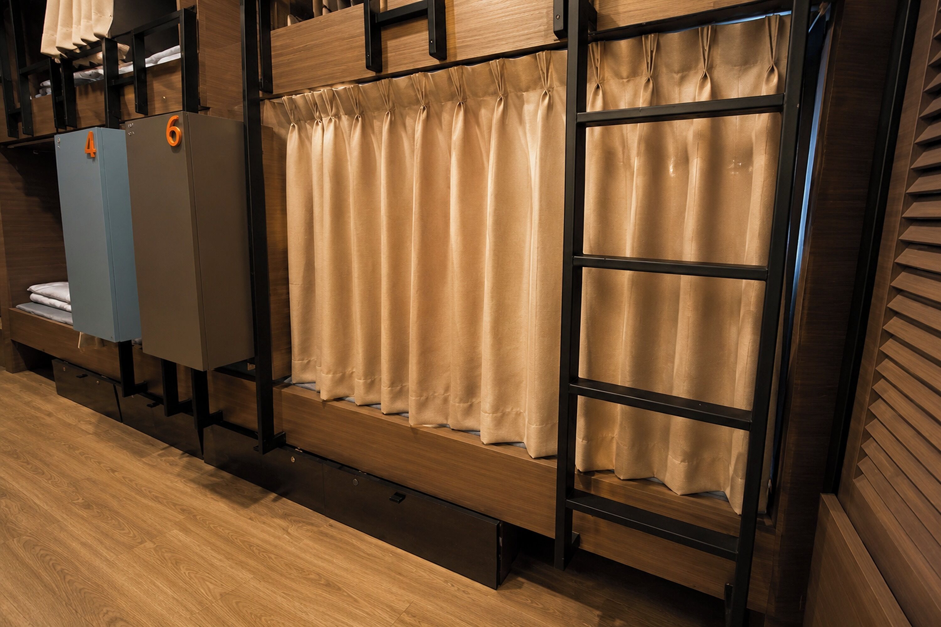 A hotel room with bunk beds, a wardrobe, and a curtain.