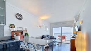 A modern kitchen with a dining area, a sofa, and a view of the sea. - MEDA CHICA Roses / Roses - INTERimmo (Rosas / Roses)