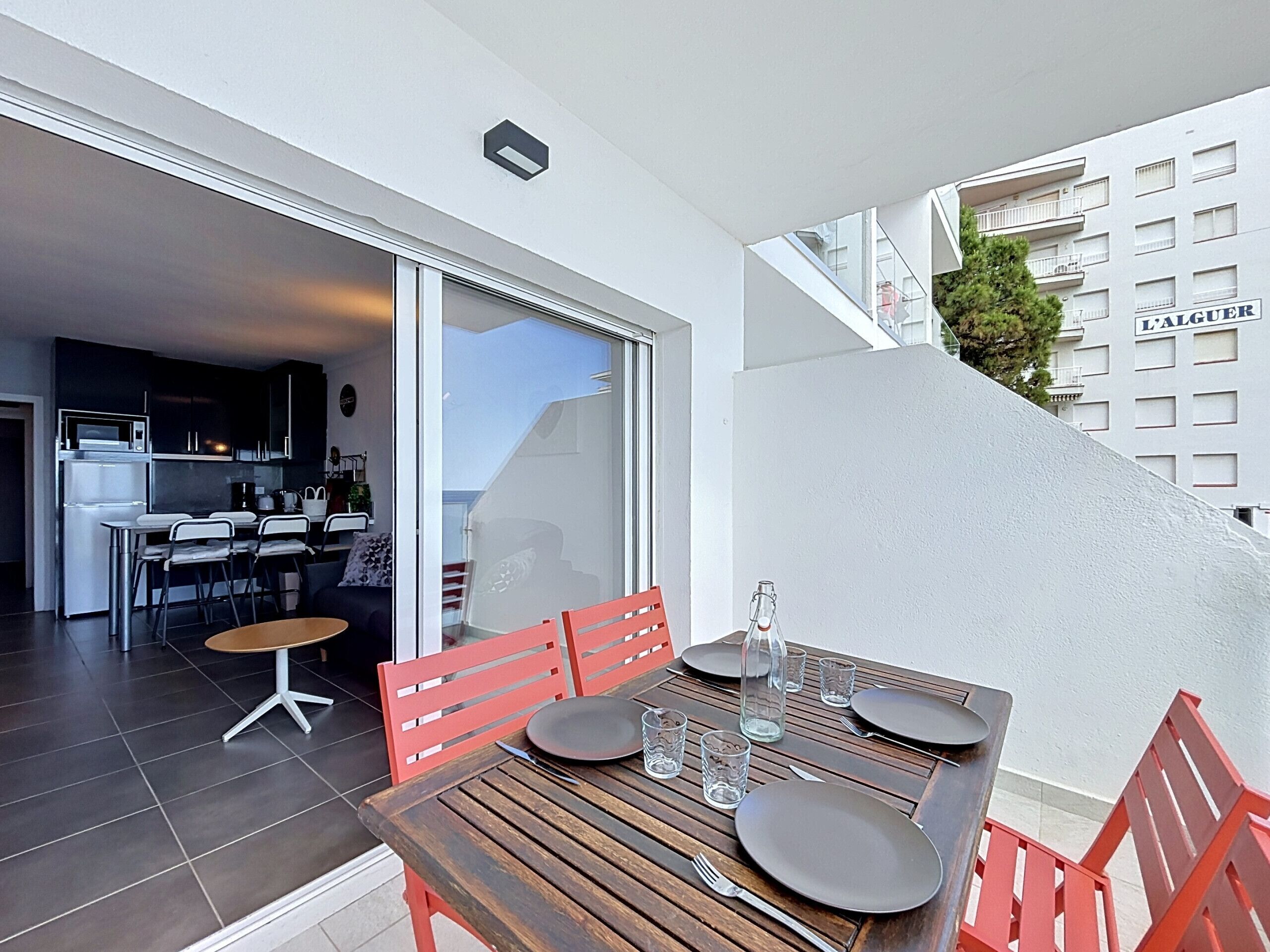 A modern apartment with a dining area, kitchen, and a view of the city.